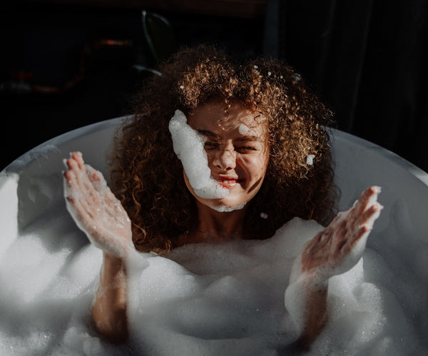 Mulher em uma banheira com espuma